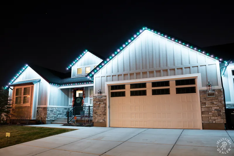 Green and white holiday roofline lighting on a farmhouse